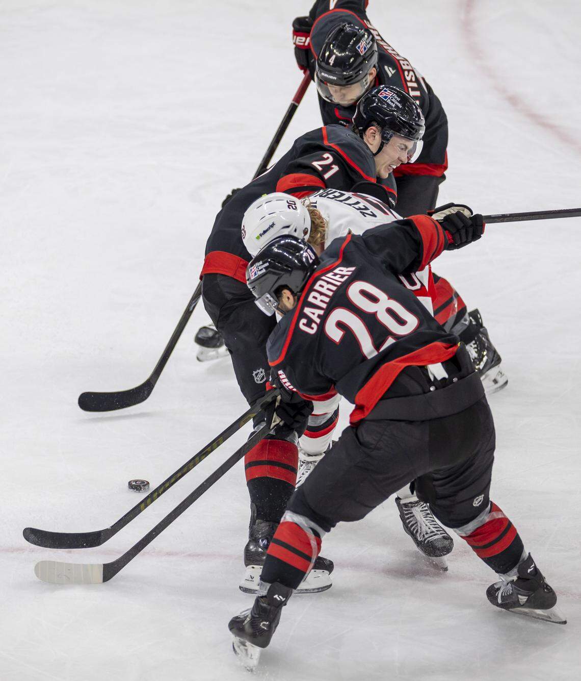 Ottawa left wing Fabian Zetterlund (20) is stopped by Carolina Hurricanes defenseman Alexander Nikishin (21) and left wing William Carrier (28) in the first overtime period of Game 2, on Monday, April 20, 2026 during the first round of the Stanley Cup Playoffs at Lenovo Center in Raleigh, N.C.