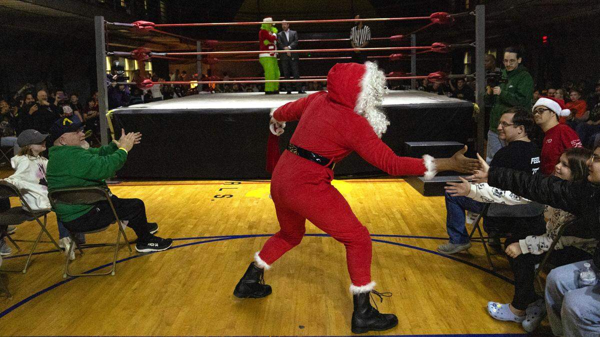 Santa greets fans as he enters the gym to wrestle The Grinch at FWE Merry Mayhem in Cary, N.C., Saturday night, Dec. 14, 2024.