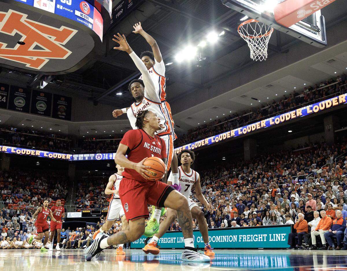 N.C. State’s Darrion Williams drives to the basket against Auburn’s Tahaad Pettiford and Kevin Overton during the second half of the Wolfpack’s 83-73 loss in the ACC/SEC Challenge on Wednesday, Dec. 3, 2025, at Neville Arena in Auburn, Ala.