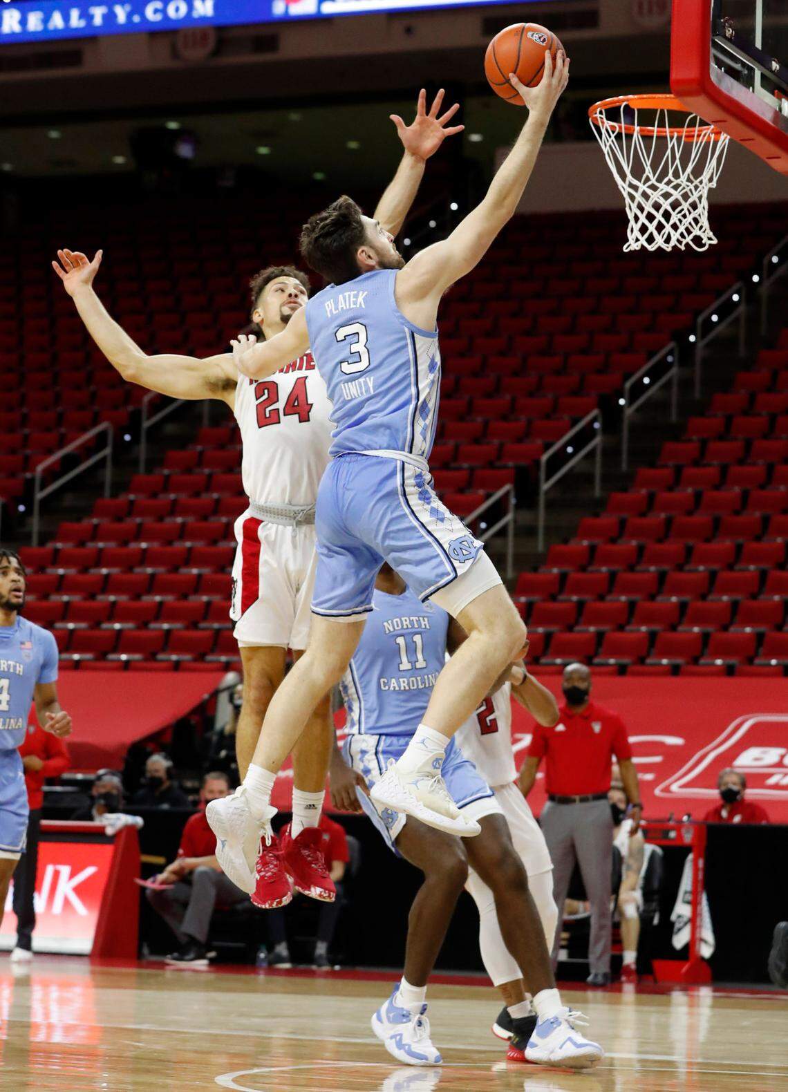 North Carolina’s Andrew Platek (3) heads to the basket past N.C. State’s Devon Daniels (24) during the first half of N.C. State’s game against UNC at PNC Arena in Raleigh, N.C., Tuesday, December 22, 2020.