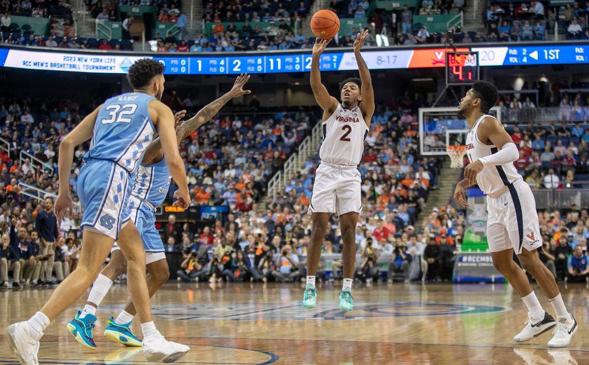 Virginia’s Reece Beekman (2) launches a three point shot over North Carolina’s Caleb Love (2) in the first half during the third round of the ACC Tournament on Thursday, March 9, 2023 at the Greensboro Coliseum in Greensboro, N.C.