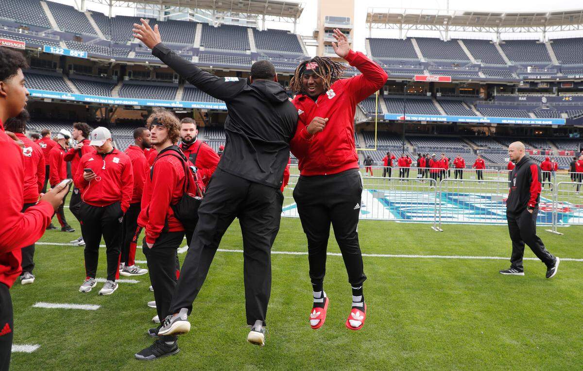 N.C. State defensive end Savion Jackson, left and offensive lineman Derrick Eason have some fun as the team tours the field at Petco Park in San Diego, CA Monday, Dec. 27, 2021, a day before the Holiday Bowl.