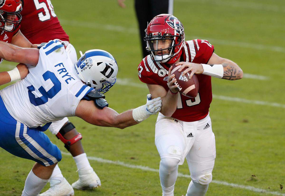 N.C. State quarterback Devin Leary (13) avoids the pressure by Duke’s Ben Frye during the second half of N.C. State’s 31-20 victory over Duke at Carter-Finley Stadium in Raleigh, N.C., Saturday, Oct. 17, 2020.