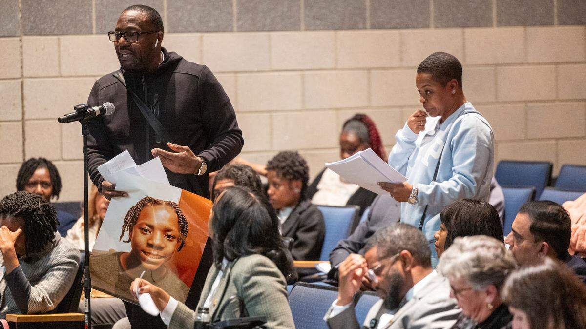 Delvin Ferrell’s uncle, Teddie Martinez, speaks while holding a portrait of Ferrell during a community forum at Southeast Raleigh High School Monday, Dec. 4, 2023, one week after a brawl resulted in the fatal stabbing of 15-year-old Ferrell and the wounding of a 16-year-old.