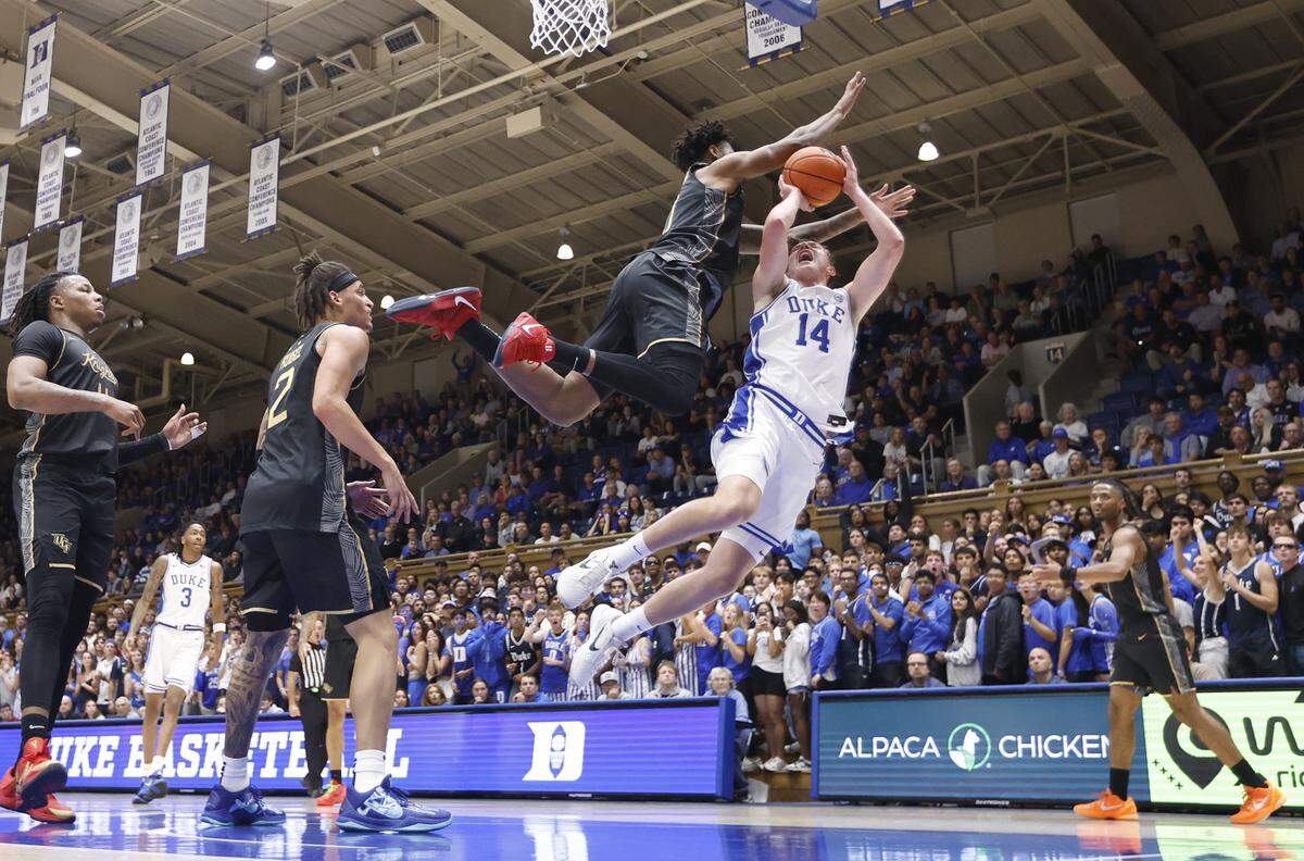 Duke’s Nikolas Khamenia (14) is fouled by UCF’s Jeremy Foumena (0) as he drives to the basket during Duke’s 96-71 exhibition victory over UCF at Cameron Indoor Stadium in Durham, N.C., Tuesday, Oct. 21, 2025.