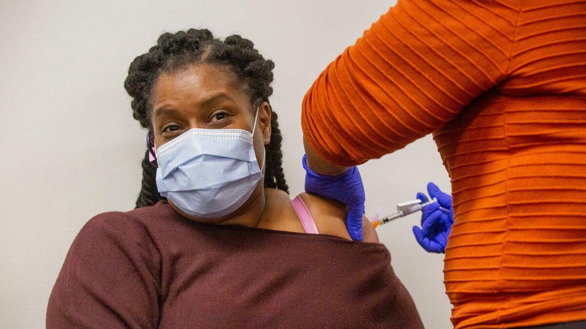 Rene Johnson, an advanced medical support assistant, receives a dose of the Pfizer COVID-19 vaccine from a fellow staff member at the Durham VA Medical Center, on Friday, Jan. 8, 2021, in Durham, N.C.