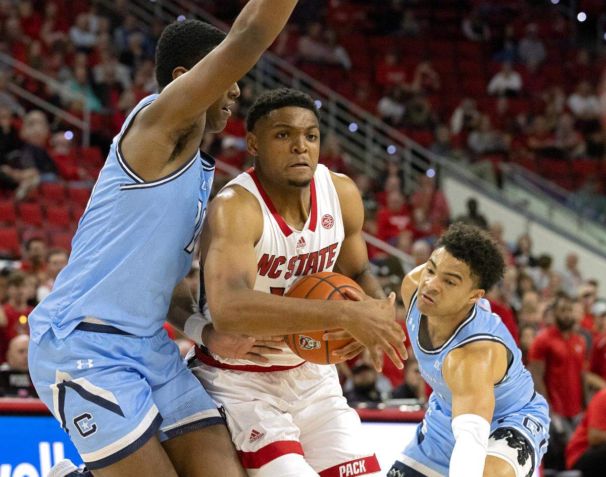 N.C. State’s Casey Morsell drives between the Citadel’s Christian Moore and Elijah Morgan during the first half of the Wolfpack’s season opener against The Citadel on Monday, Nov. 6, 2023, at PNC Arena in Raleigh, N.C.