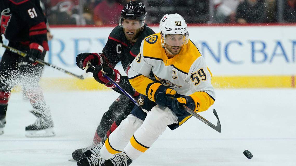 Nashville Predators defenseman Roman Josi (59) and Carolina Hurricanes center Jordan Staal (11) skate for the puck during the second period in Game 2 of an NHL hockey Stanley Cup first-round playoff series in Raleigh, N.C., Wednesday, May 19, 2021. (AP Photo/Gerry Broome)