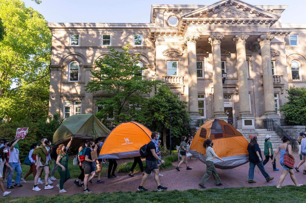 Demonstrators march outside an event attended by former UNC-Chapel Chancellor Kevin Guskiewicz during a pro-Palestinian protest and encampment at UNC Chapel Hill on Monday, April 29, 2024. Students for Justice in Palestine urged students to join the encampment, saying that university officials had told them that the “tents are coming down tonight.”