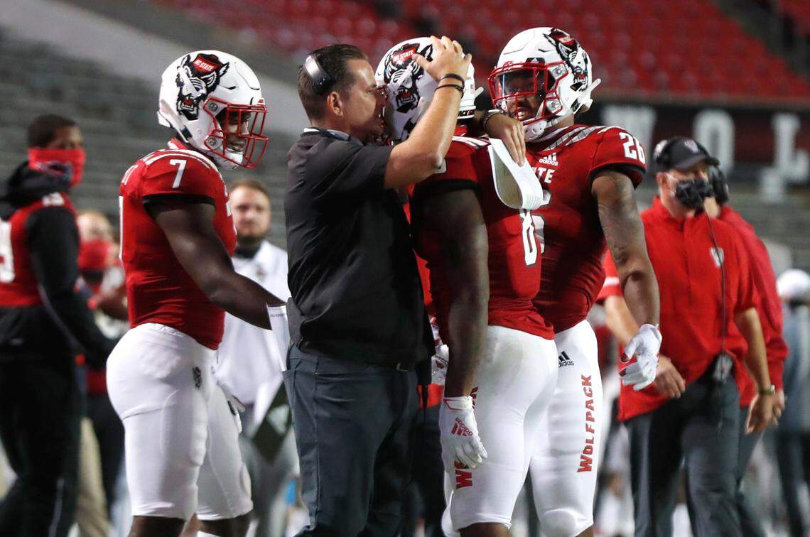 N.C. State offensive coordinator Tim Beck talks with running back Ricky Person Jr. (8) during the first half of N.C. State’s game against Wake Forest at Carter-Finley Stadium in Raleigh, N.C, Saturday, Sept. 19, 2020.