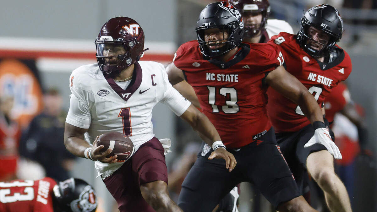 On third down, Virginia Tech quarterback Kyron Drones (1) escapes the pressure by N.C. State defensive end Travali Price (13) and throws a first down during the first half of N.C. State’s game against Virginia Tech at Carter-Finley Stadium in Raleigh, N.C., Saturday, Sept. 27, 2025.