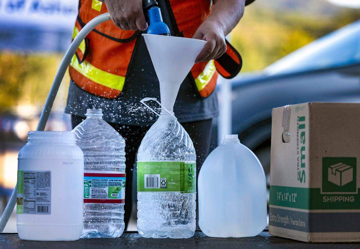 Volunteers fill water containers for residents of Black Mountain, N.C. at the Ingles store on NC 9 on Tuesday, October 8, 2024.