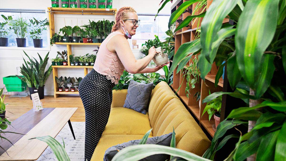 Jaspa Weis, an employee at Urban Pothos in Raleigh, moves plants around the shop on Friday, Aug. 20, 2021. The plant shop opened during the pandemic.