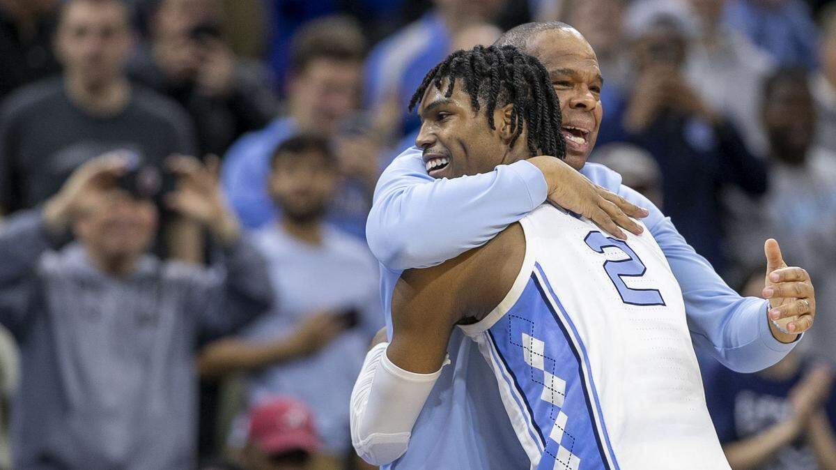 North Carolina coach Hubert Davis embraces Caleb Love (2) as Davis takes his starters out of the game, after securing their victory over Saint Peters in the NCAA East Regional final on Sunday, March 27, 2022 at Wells Fargo Center in Philadelphia, Pa.