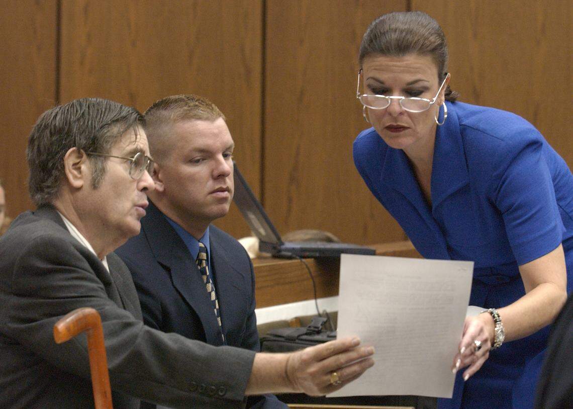 From left, attorney Tom Loflin, male escort Brent Wolgamott and Durham assistant district attorney Freda Black look over an email during the Michael Peterson murder trial on Aug. 11, 2003.