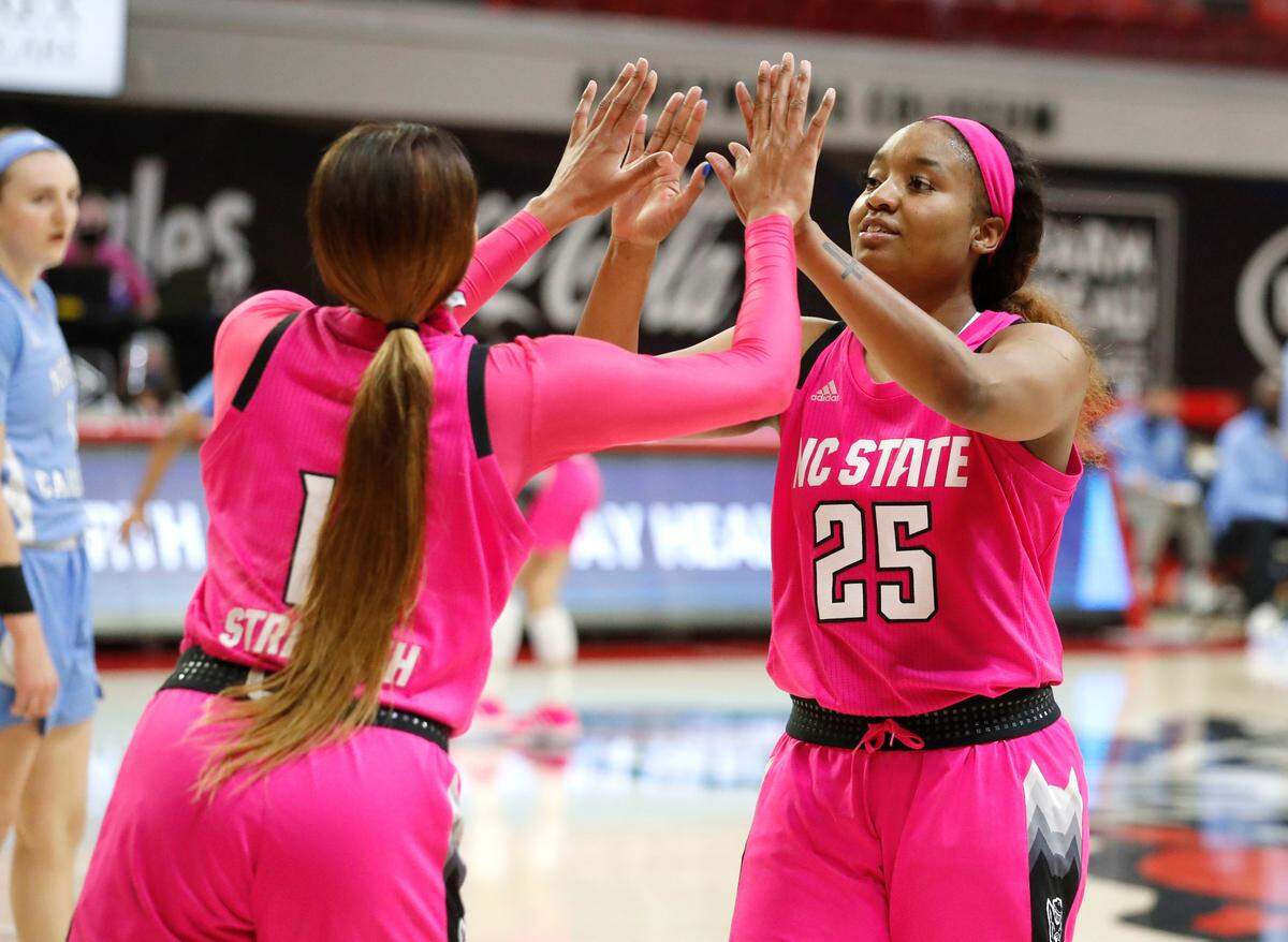 N.C. State’s Jakia Brown-Turner (11) and Kayla Jones (25) congratulate each other during the second half of N.C. State’s 82-63 victory over UNC in the annual Play4Kay game at Reynolds Coliseum in Raleigh, N.C., Sunday, February 21, 2021.