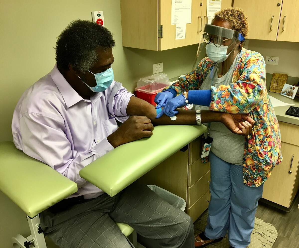 Dr. Ernest Grant is participating in the COVID-19 vaccine phase three clinical trials hosted by UNC researchers. He is getting a shot in his arm.