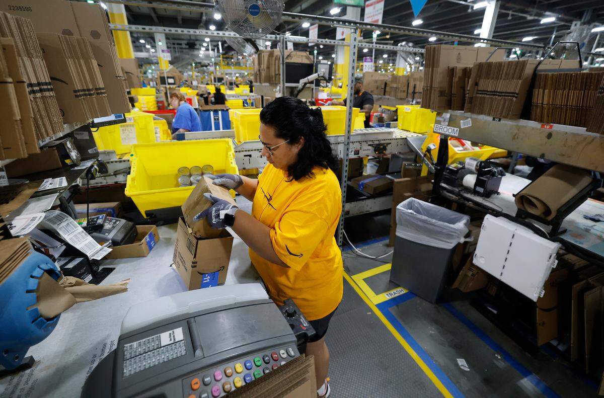 Dulce Valle Gutierrez packs items at RDU1, an Amazon Robotics Fulfillment Center in Garner, N.C., Tuesday, July 1, 2025.