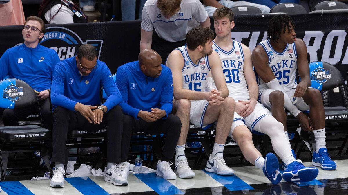 Duke’s Ryan Young (15), Kyle Filipowski (30) and Mark Mitchell (25), sit quietly on the bench following their 76-64 loss to N.C. State in the NCAA South Regional final on Sunday, March 31, 2024 at the American Airlines Center in Dallas, Texas.