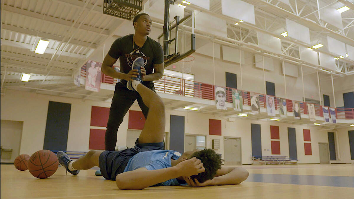 Trainer Curtis Hines works with a young Kinston basketball player in the documentary “Something in the Water: A Kinston Basketball Story.”