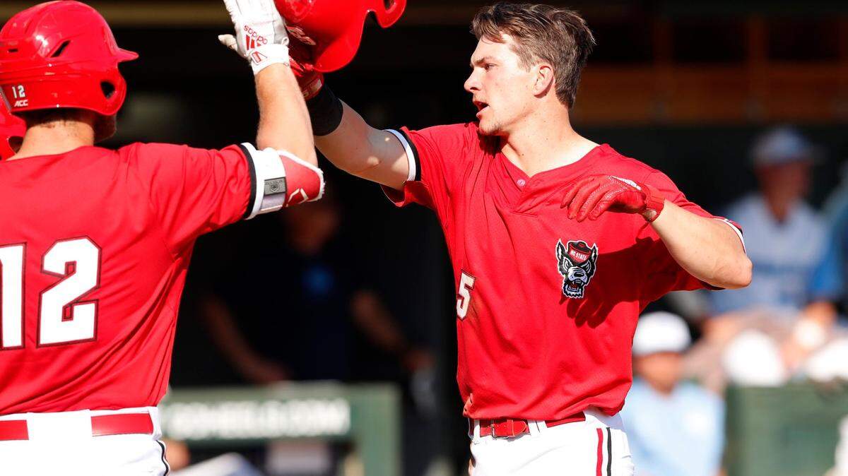 N.C. State’s Patrick Bailey (5) celebrates with Brad Debo (12) after scoring in the third inning during N.C. State’s game against UNC at Boshamer Stadium in Chapel Hill, N.C., Saturday, May 18, 2019.