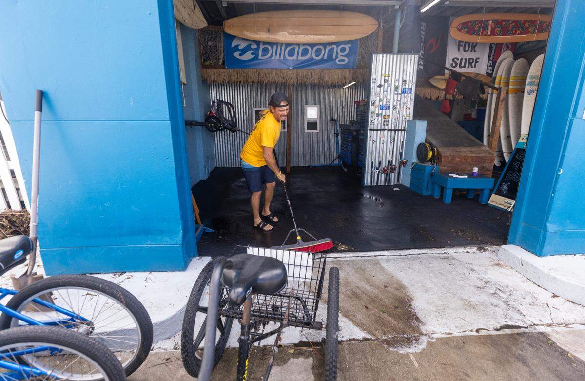 Bryan Sartin, owner of Pleasure Island Rentals, sweeps water from his business as floodwaters recede in Carolina Beach on Tuesday, Sept. 17, 2024 after an unnamed storm dropped as much as 18 inches of rain in southeastern North Carolina over a 72-hour period. Flood Levels in Carolina Beach rivaled that of Hurricane Floyd in 1999.