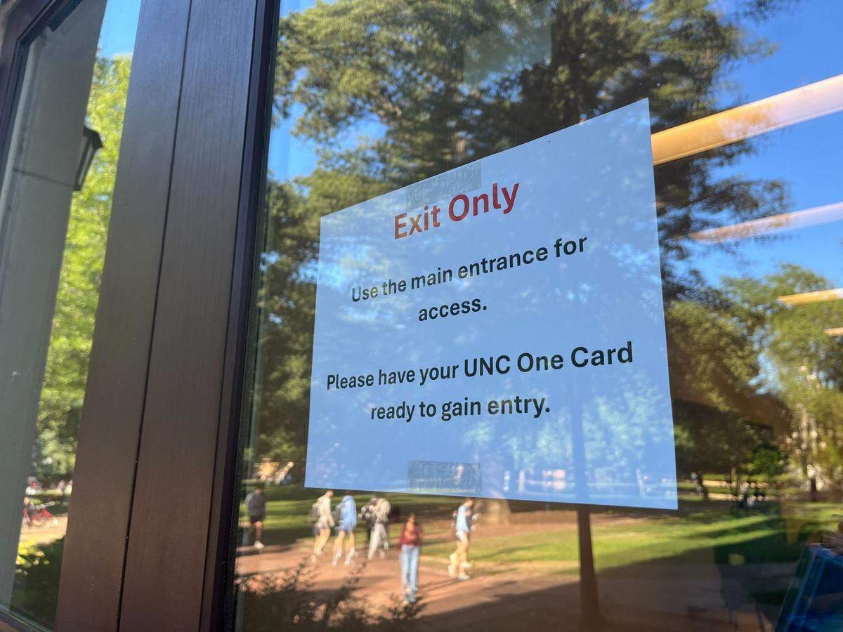 A sign is posted on a side entrance of Hanes Hall on the UNC-Chapel Hill instructs people to instead enter through the building’s main entrance on Tuesday, Oct. 8, 2024.