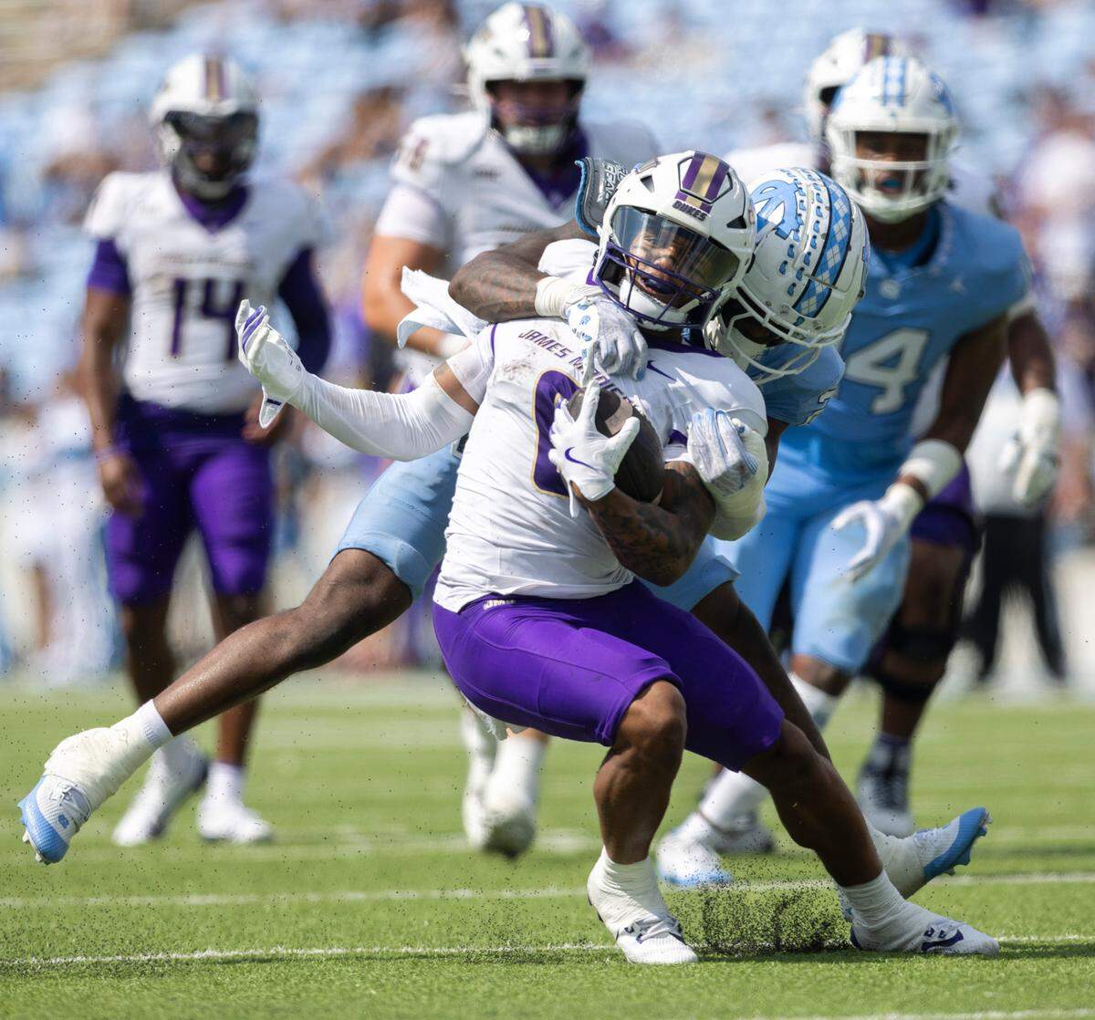 North Carolina defensive back Kaleb Cost (21) works to stop James Madison wide receiver Yamir Knight (0) after a seven yard pass completion from quarterback Alonza Barnett III in the third quarter on Saturday, September 21, 2024 at Kenan Stadium in Chapel Hill, N.C.