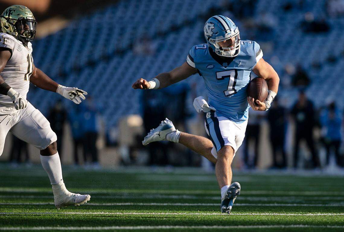North Carolina quarterback Sam Howell (7) scores the game winning touchdown on a 20-yard carry ahead of Wake Forest’s Miles Fox (11) late in the fourth quarter to give the Tar Heels’ a 52-45 lead.