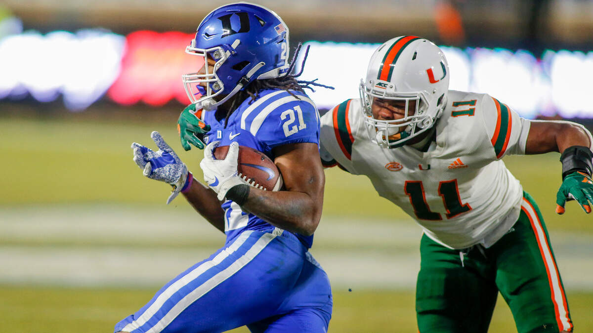 Duke Blue Devils running back Mataeo Durant (21) carries the football as Miami Hurricanes linebacker Corey Flagg Jr. (11) closes in during the second half at Wallace Wade Stadium Saturday, Dec. 5, 2020.