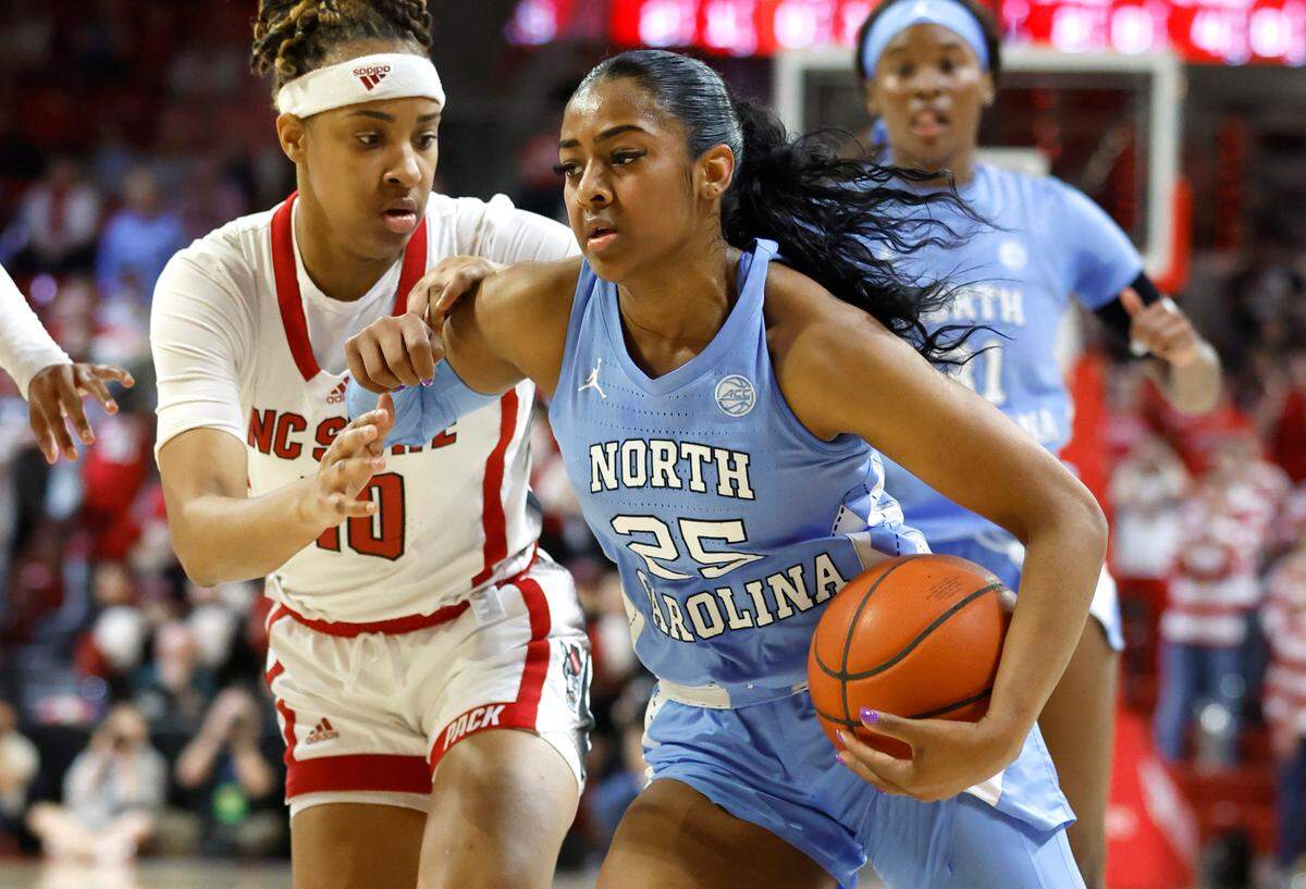 North Carolina’s Deja Kelly (25) drives by N.C. State’s Aziaha James (10) during the first half of N.C. State’s game against UNC at Reynolds Coliseum in Raleigh, N.C., Thursday, Feb. 16, 2023.