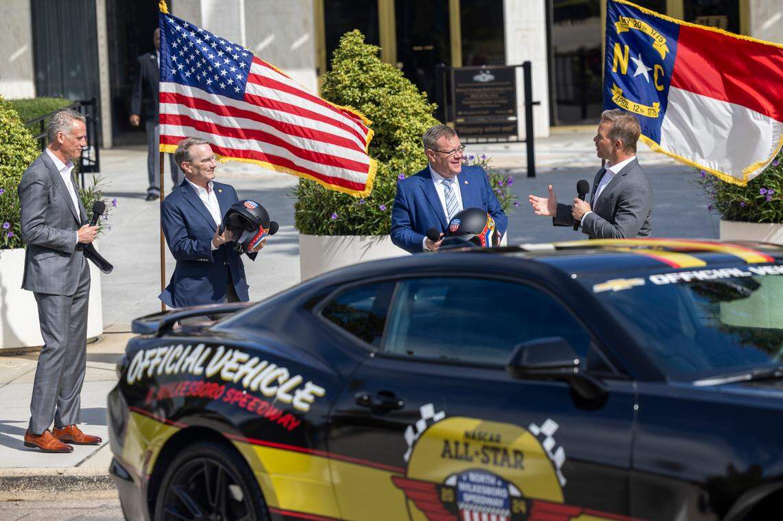 NASCAR President Steve Phelps, left, and Speedway Motorsports President and CEO Marcus Smith, right, present Senate Majority Leader Paul Newton, second from left, and House Speaker Tim Moore with vintage-style racing helmets during an announcement Thursday, Sept 28, 2023 outside the North Carolina Legislative Building in downtown Raleigh, that the NASCAR All-Star Race will be held May 17-19 at the North Wilkesboro Speedway.