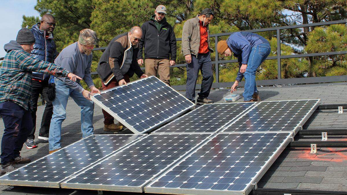 Workers with the NC Clean Energy Technology Center, based at N.C. State University, install a rooftop solar collection system. The Center was one of the groups helping to decide how best to spend more than $150 million in federal grants through the Solar for All program when President Donald Trump’s EPA chief announced the grants would be canceled. North Carolina says the cancellation was illegal and has sued to get the funding restored.