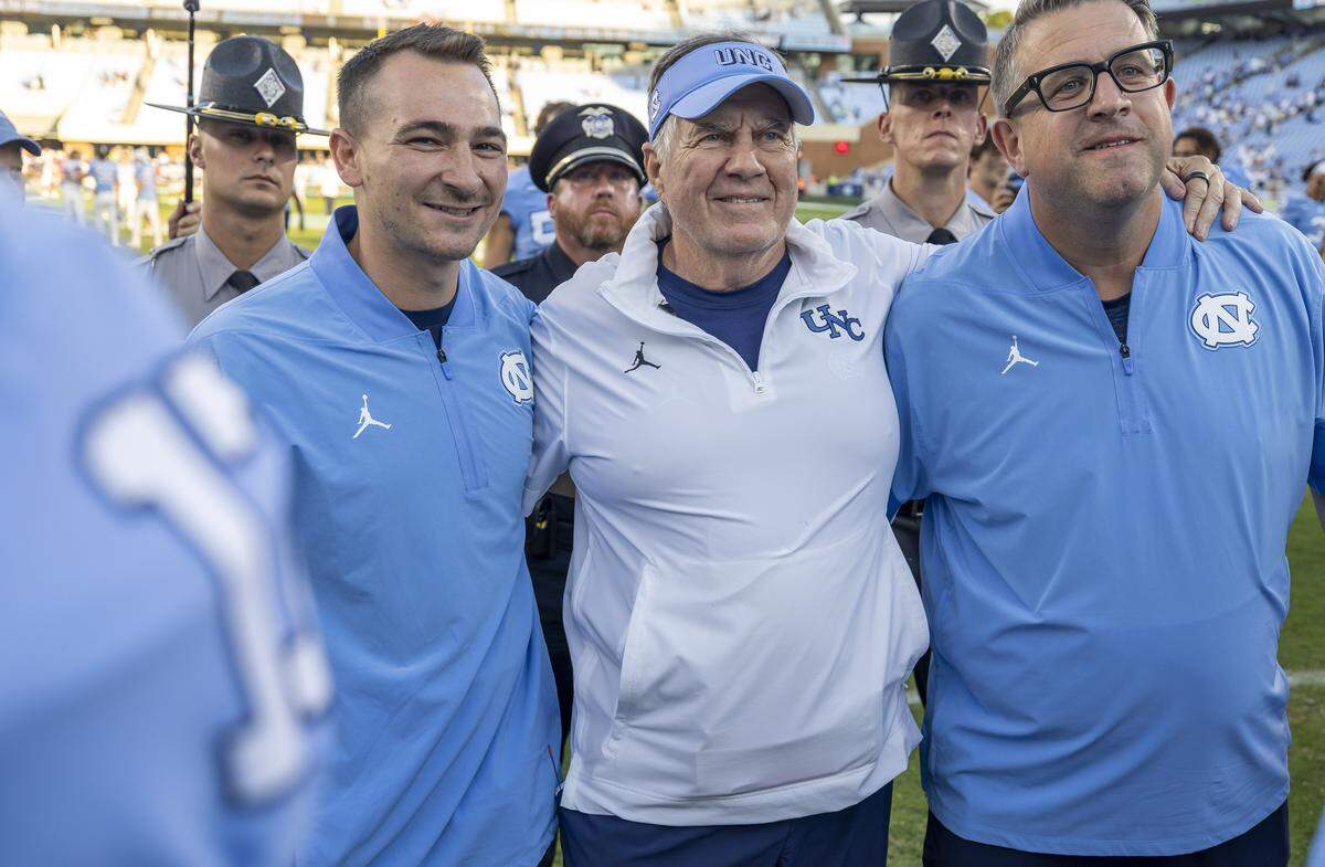North Carolina coach Bill Belichick embraces his staff as they stand for the Alma Mater following the Tar Heels’ 41-6 victory over Richmond on Saturday, September 13, 2025 at Kenan Stadium in Chapel Hill, N.C.