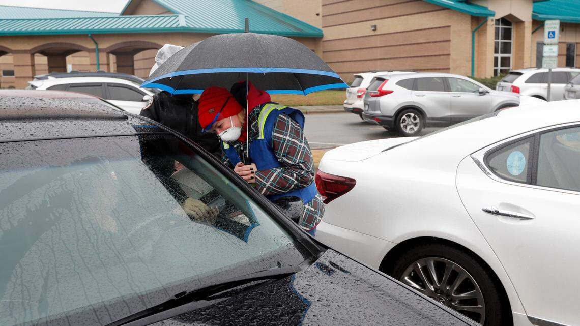 Mary Heilig, a social worker with Johnston County Health Department, checks to make sure individuals are 75 or older during a drive-thru COVID vaccination clinic at West Johnston High School in Benson, N.C., Tuesday, January 12, 2021. The Johnston County Health Department clinic was for anyone 75 and older and was offered first come, first served for the first 500 who arrived.