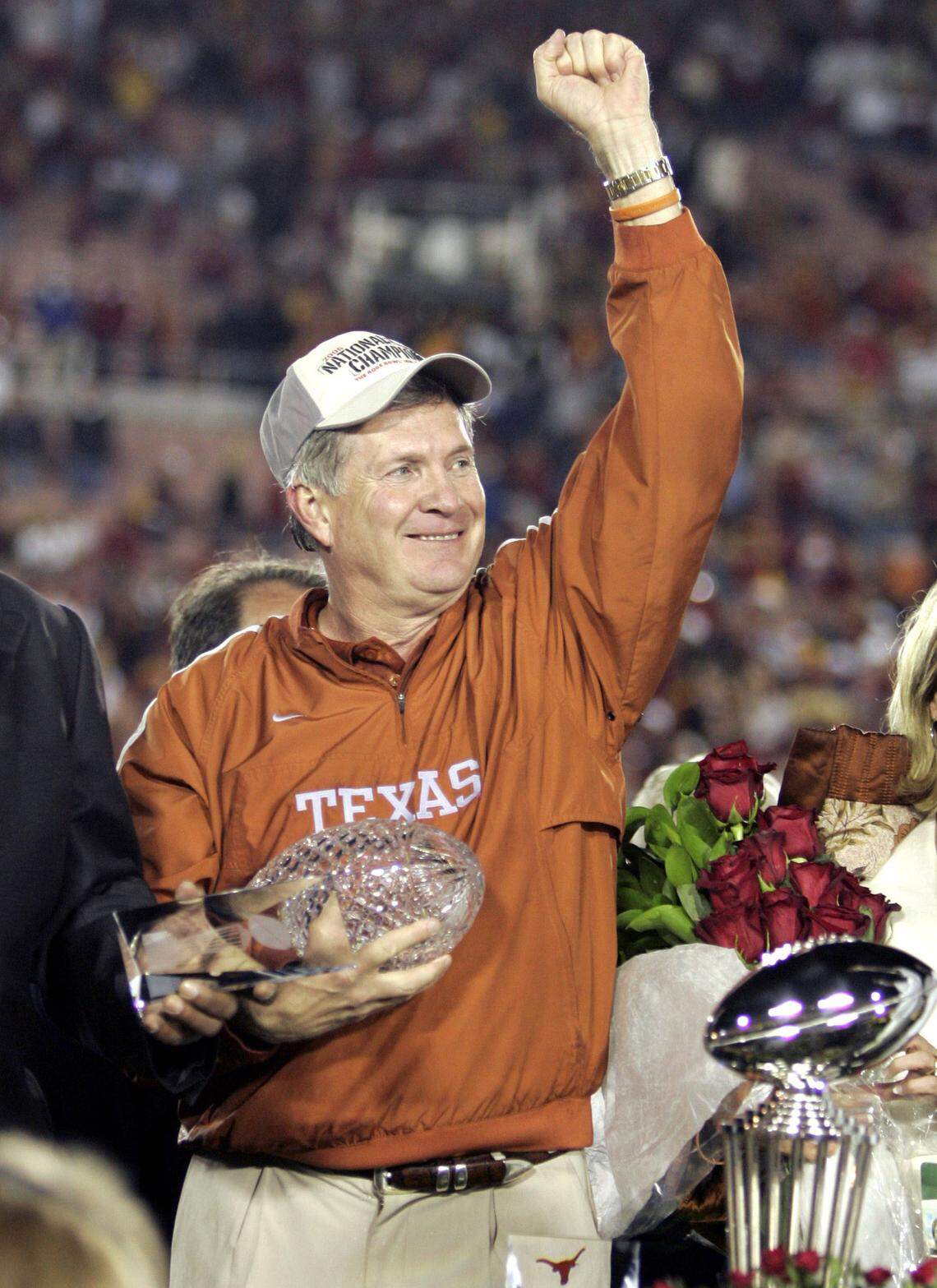 Texas head coach Mack Brown celebrates with the championship trophy after Texas beat Southern California 41-38 in the Rose Bowl, the national championship college football game in Pasadena, Calif., in 2006.