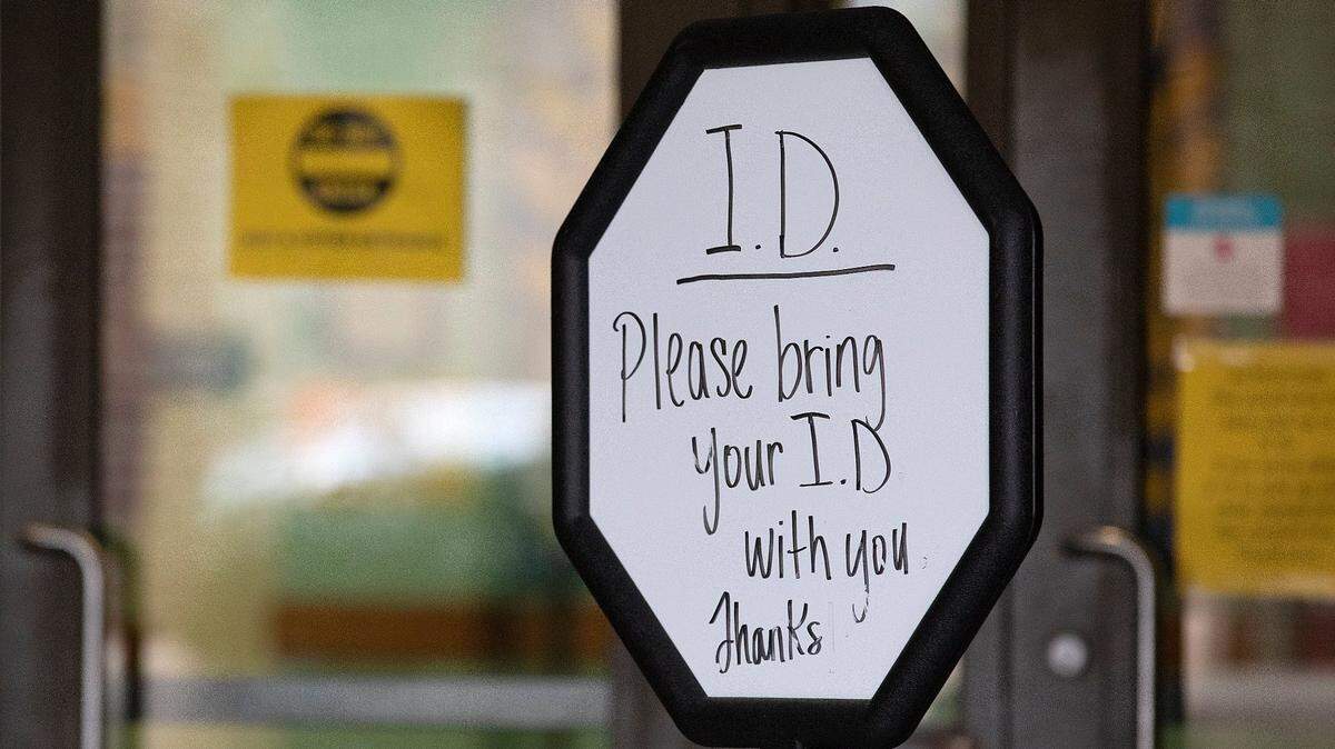 A sign alerts people to bring identification outside of a voting site at Aversboro Elementary School in Garner, N.C. on Tuesday, March 5, 2024.