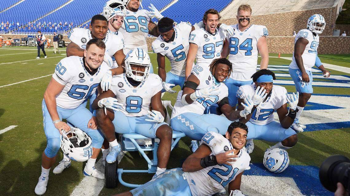 North Carolina Tar Heels players celebrate keeping the victory bell after their win over the Duke Blue Devils at Wallace Wade Stadium.