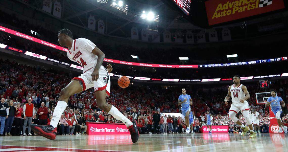 N.C. State’s Ernest Ross (24) saves the ball from going out of bounds, passing it to Casey Morsell (14) for a basket during N.C. State’s 77-69 victory over UNC at PNC Arena in Raleigh, N.C., Sunday, Feb. 19, 2023.