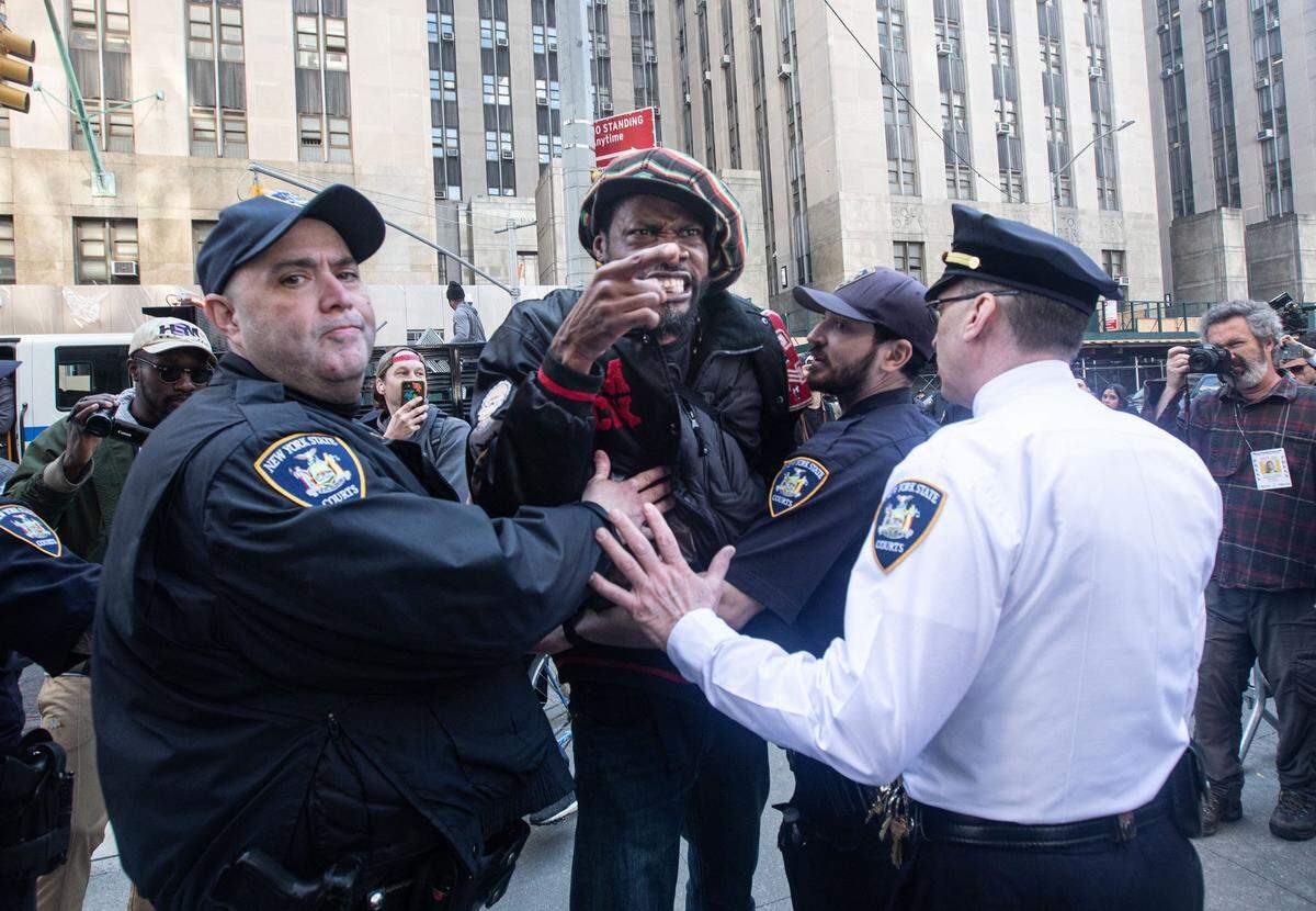 An anti-Donald Trump protestor is held back from engaging with a pro-Trump protestor across the street from the Manhattan Criminal Courthouse April 4, 2023.