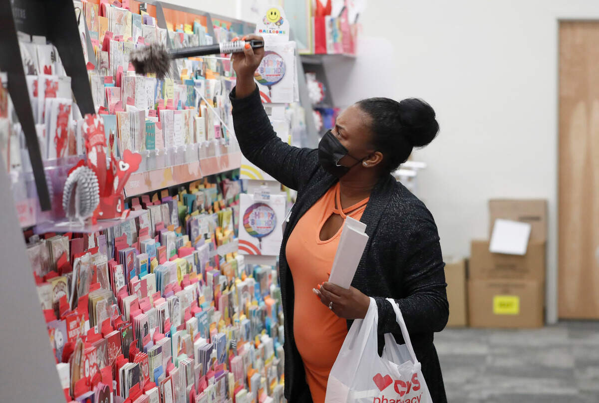 Tosha Tyler, store manager at the CVS on Fayetteville St. in downtown Raleigh, N.C., dusts the shelves Friday, February 5, 2021.