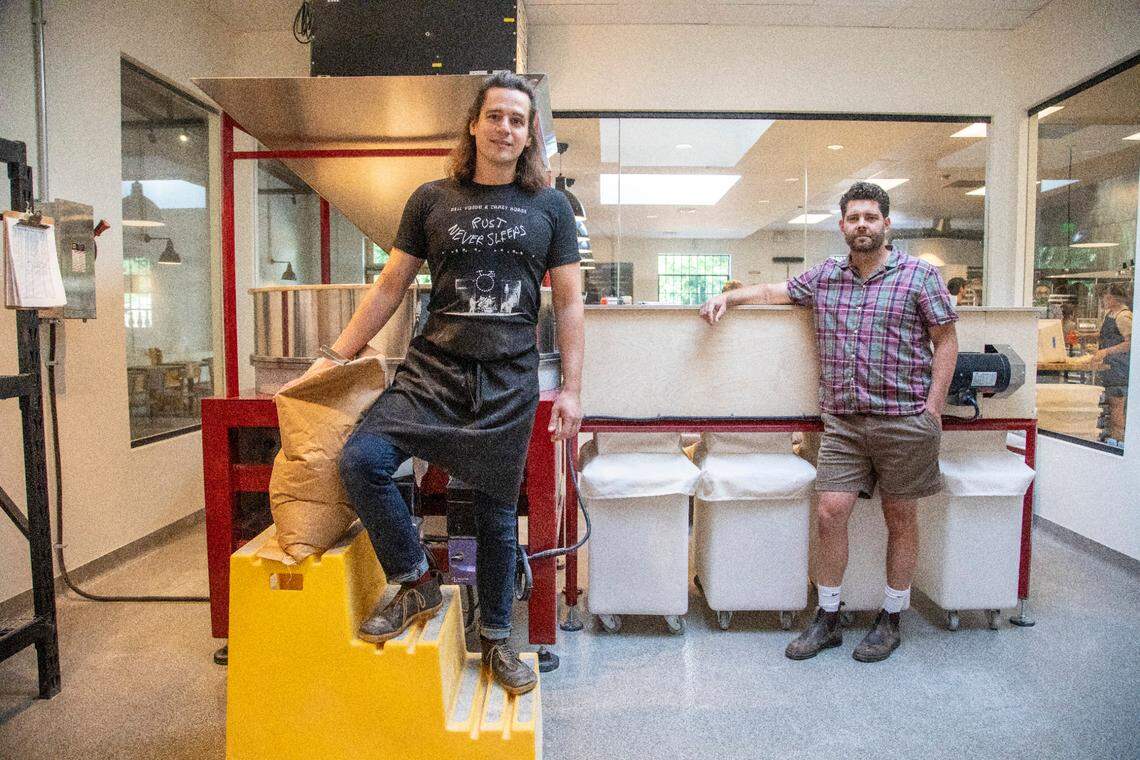 Co-owners Joshua Bellamy, left, and Sam Kirkpatrick in the milling room at Boulted Bread’s new location on Dupont Circle in Raleigh on Friday, May 12, 2023.
