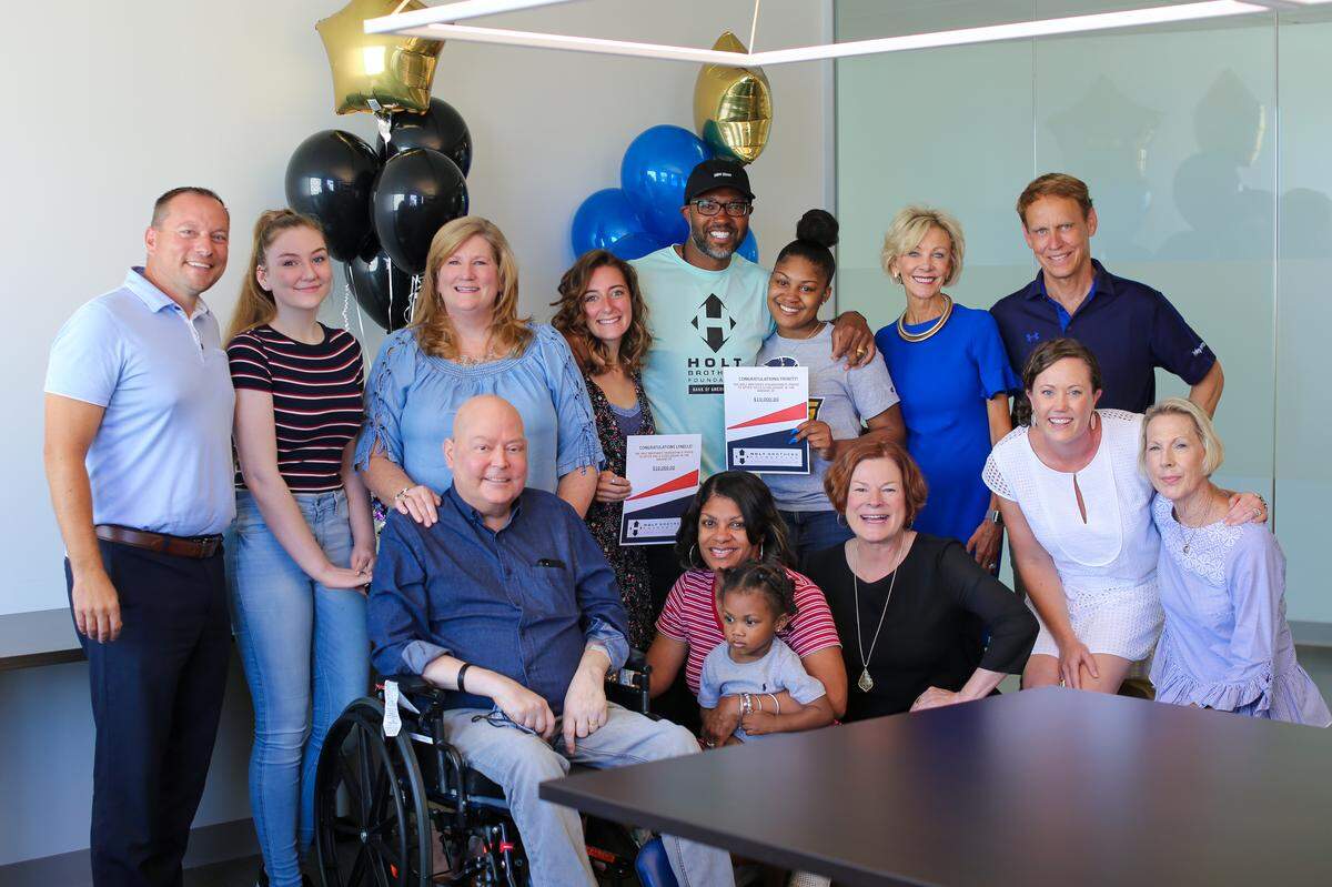Torry Holt, center, and Holt Brothers Foundation board members pose with the some of the winners and their families of the Holt Brothers Foundation KidsCan scholarship in August 2019.