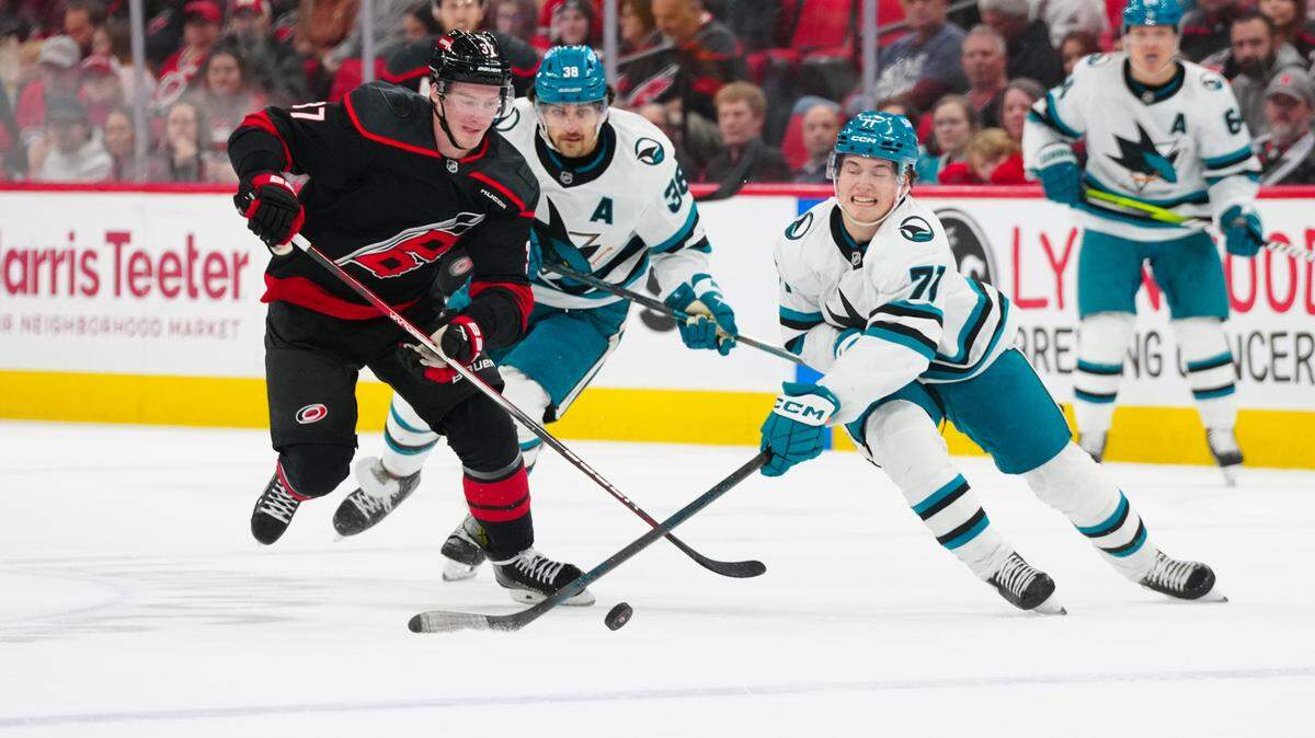 San Jose Sharks center Macklin Celebrini (71) and Carolina Hurricanes right wing Andrei Svechnikov (37) chased after the puck during the first period at Lenovo Center.