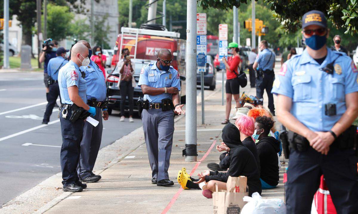Raleigh police talk with protesters sitting across the street from the N.C. Executive Mansion in Raleigh, N.C., Tuesday morning, June 30, 2020. The demonstraters camped out overnight Monday to protest a new bill that further limits public access to death investigation records.