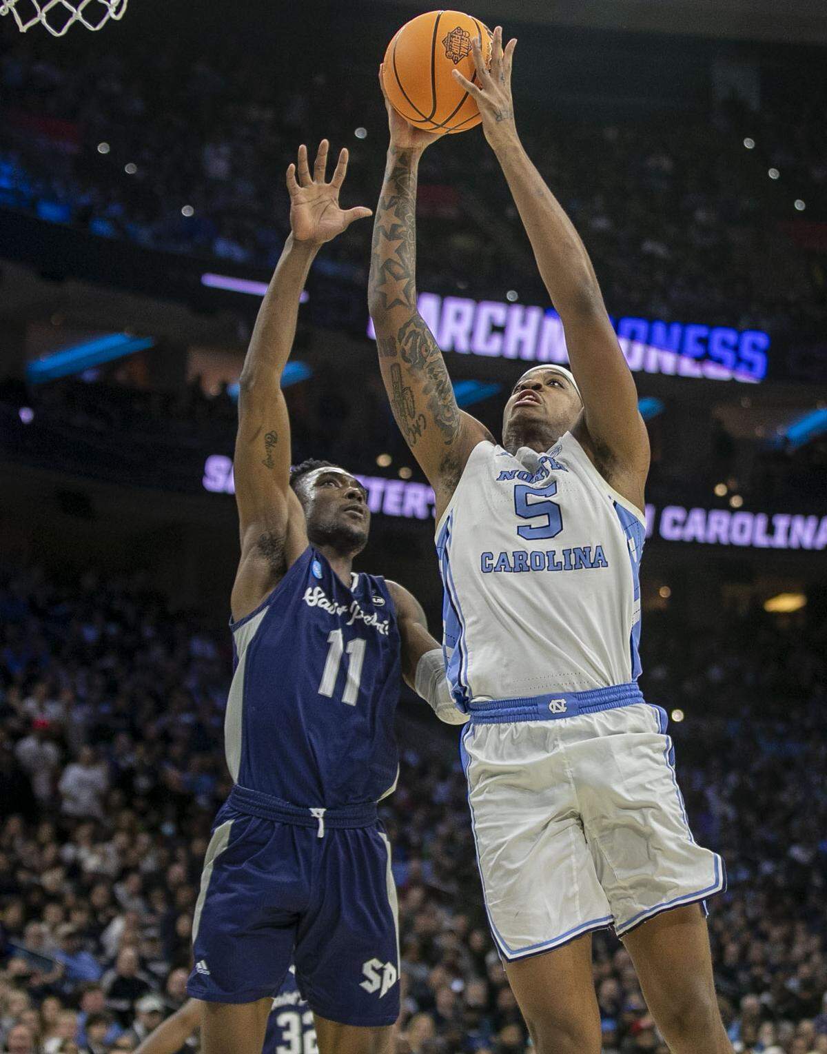 North Carolina’s Armando Bacot (5) breaks to the basket against Saint Peter’s KC Ndefo (11) during the second half in the NCAA East Regional final on Sunday, March 27, 2022 at Wells Fargo Center in Philadelphia, Pa.