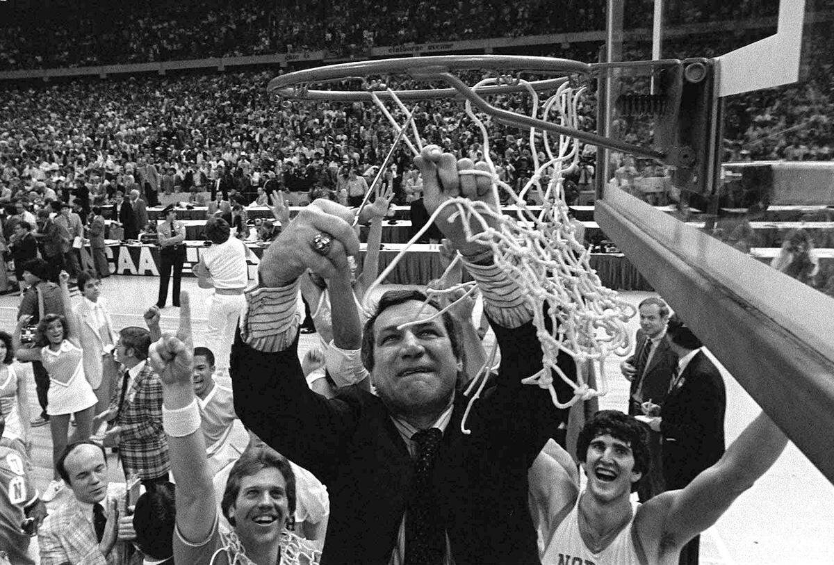 North Carolina basketball coach Dean Smith cuts the net as happy players and fans cheer after the Tar Heels defeated Georgetown for the NCAA Championship March 29, 1982 in New Orleans.