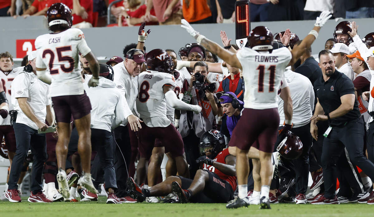 The Virginia Tech sideline erupts after N.C. State tight end Justin Joly (7) canÕt pull in the reception on fourth down with 45 seconds left in the game during Virginia TechÕs 23-21 victory over N.C. State at Carter-Finley Stadium in Raleigh, N.C., Saturday, Sept. 27, 2025.