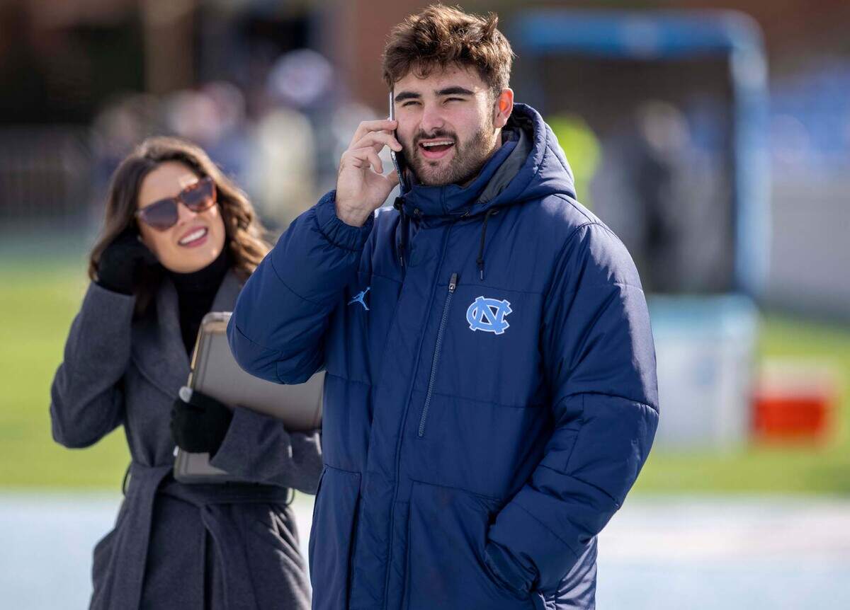 North Carolina quarterback Sam Howell, dressed in street clothes, takes a call on his phone an hour before the Tar Heels’ game against Wofford on Saturday, November 20, 2021 at Kenan Stadium in Chapel Hill, N.C.