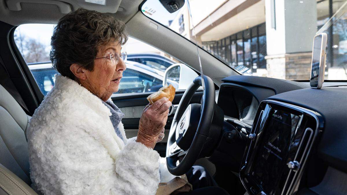 Carol Chapman, known as Grandma C, makes a TikTok on National Bagel Day tasting a bagel from New York Bagel and Deli in North Raleigh, Wednesday, Jan. 15, 2025. Grandma C said the plain bagel, lightly toasted, with olive and pimento cream cheese, is a “great bagel.”